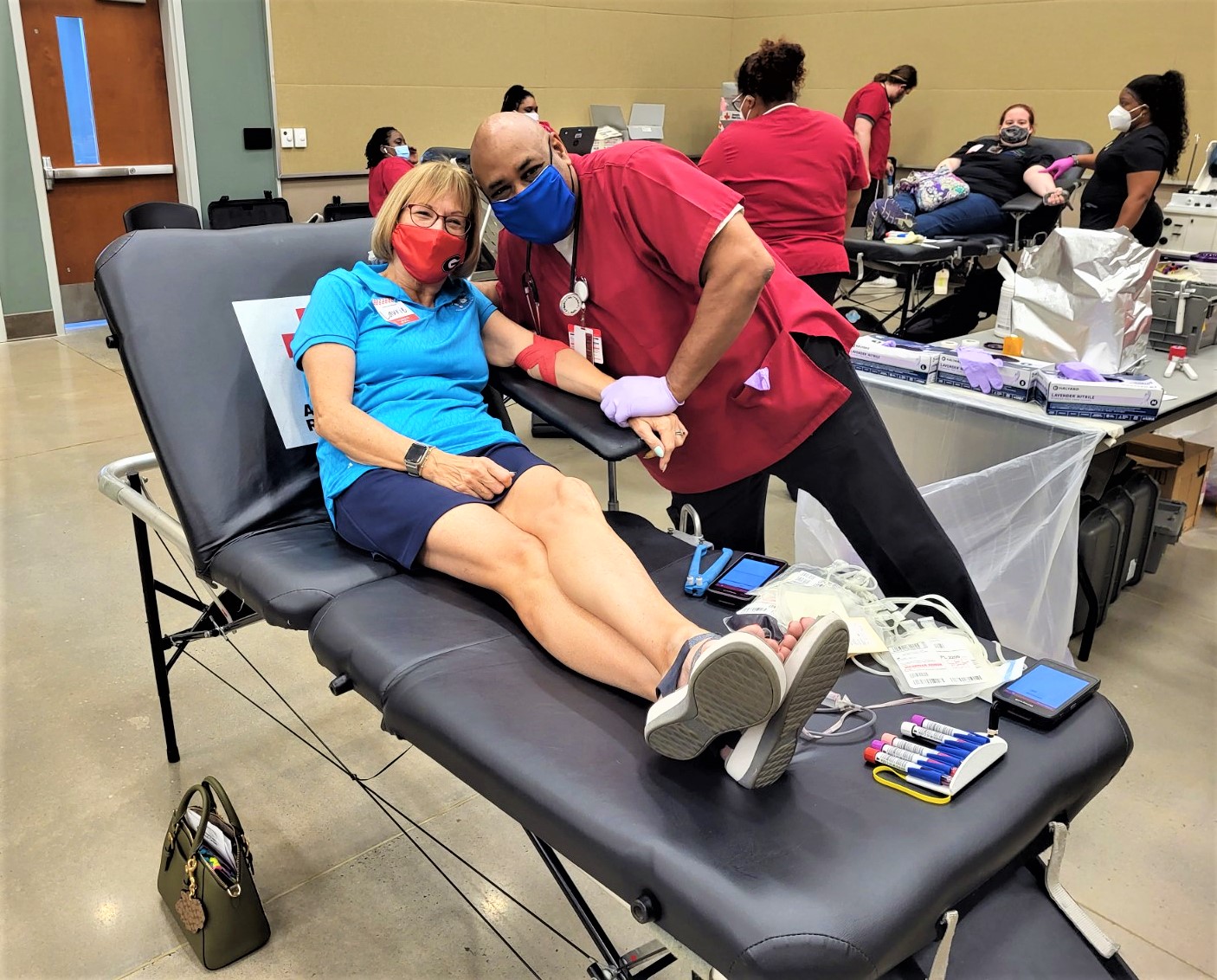 Laurie Badone donating blood with Red Cross staff Johnnie Walker