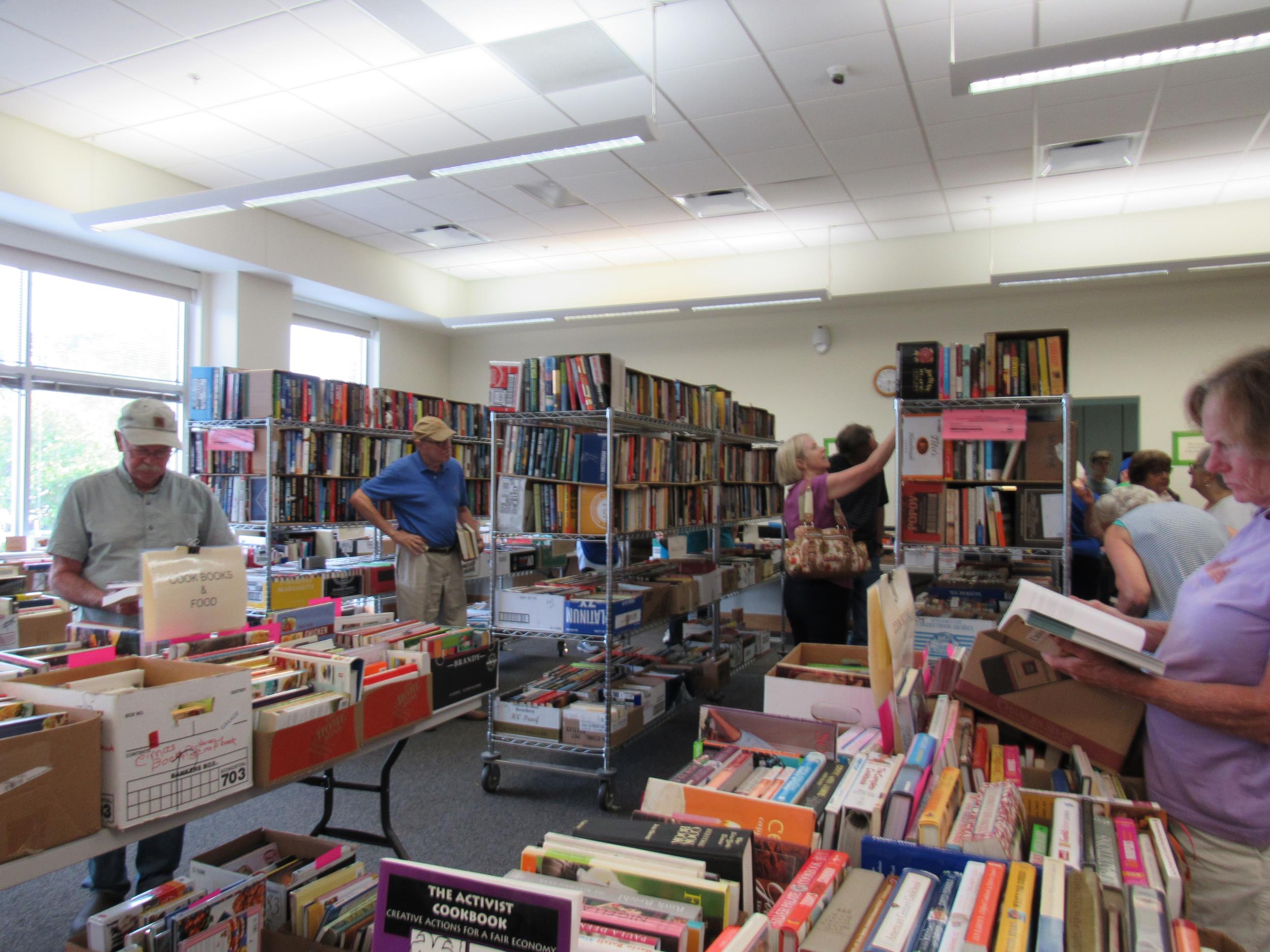 Tables of books and people looking at books