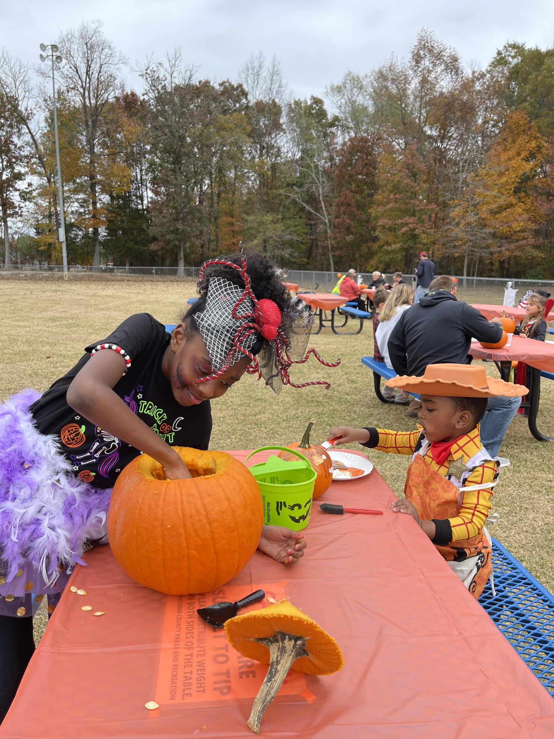 Trunk or Treat - two kids carving pumpkins