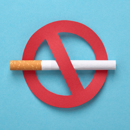 A cigarette is shown in the middle of a big red circle and diagonal line over it on a light blue background.