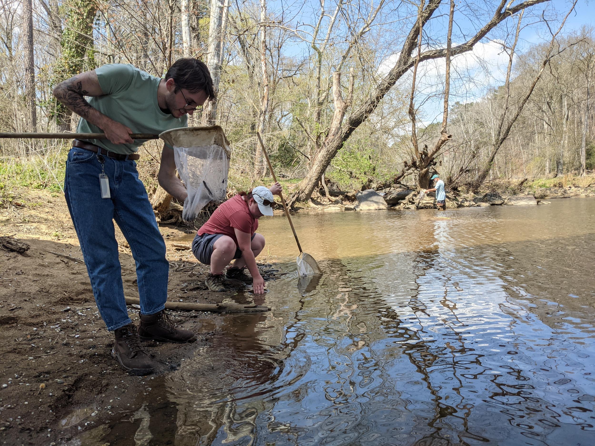 Individuals cleaning up the Haw River during Creek Week 2023