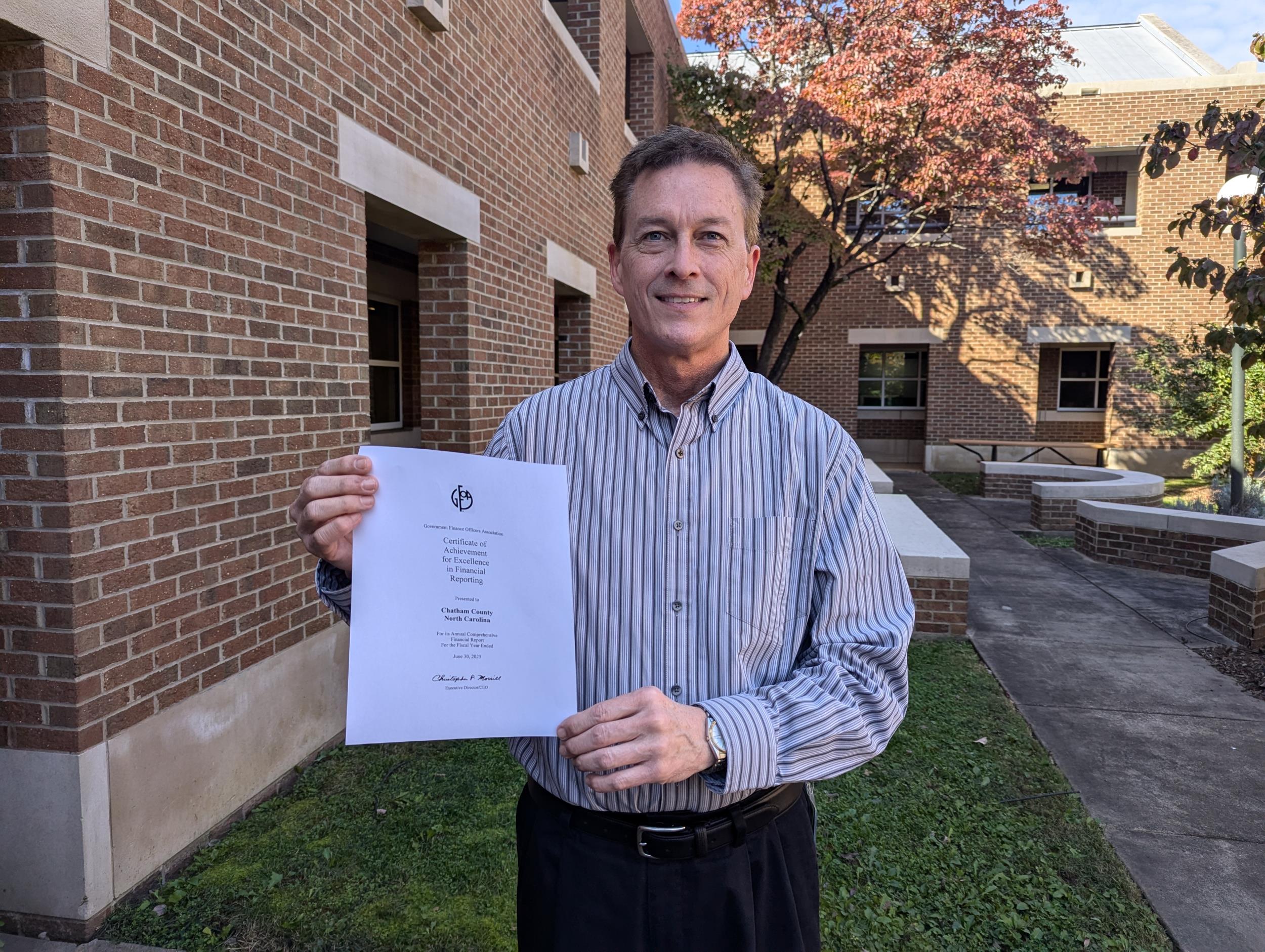 Chatham County Finance Director Roy Lynch holds the Certificate of Achievement for Excellence in Financial Reporting by the Government Finance Officers Association of the United States and Canada (GFOA).