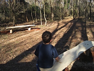 A student sits on a bench in an outdoor classroom.